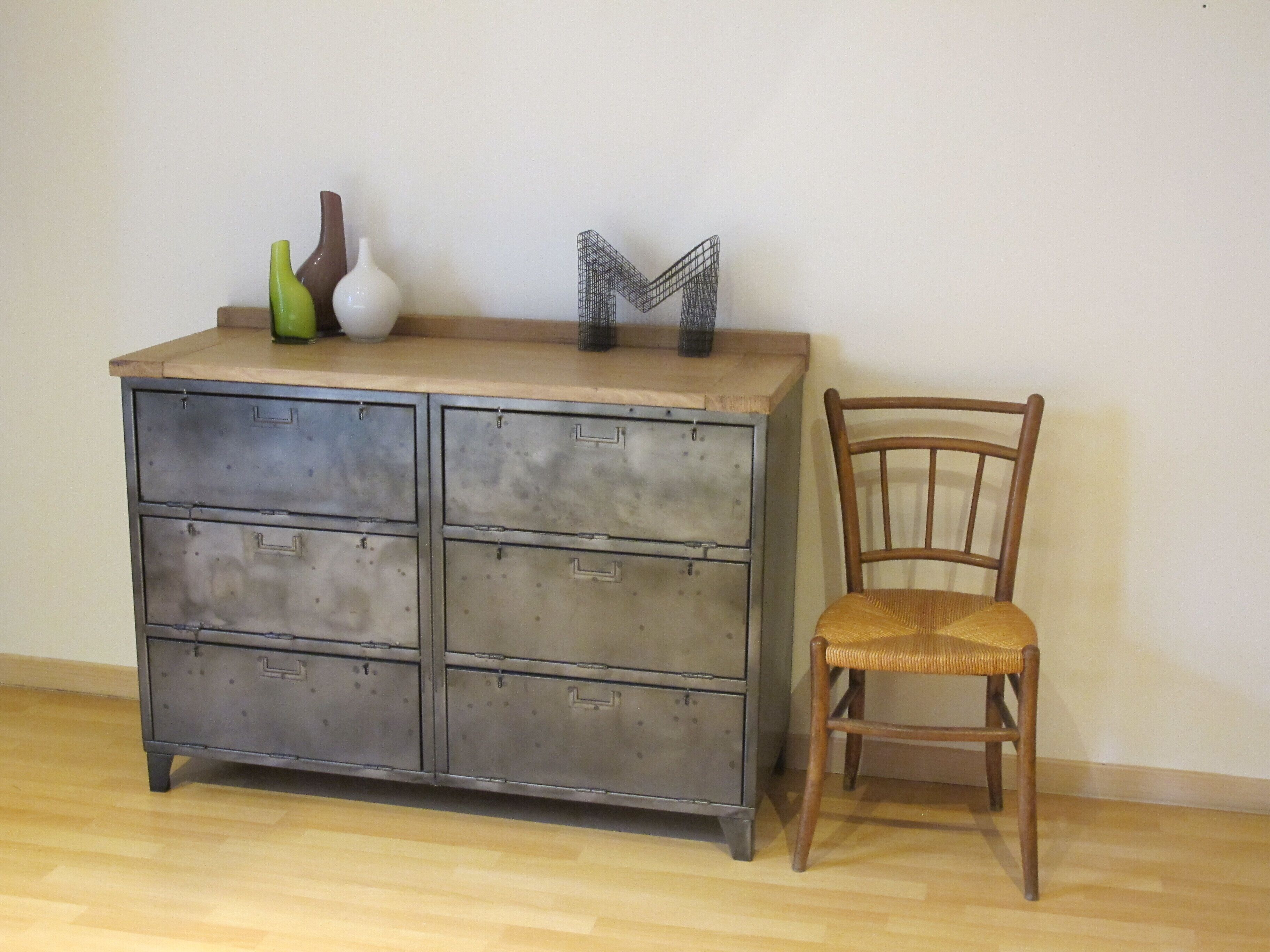 A metal filing cabinet with drawers and a wooden chair beside it.