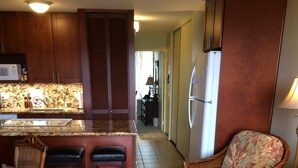 A compact living space with a kitchen area, a dining table with two chairs, a sofa, and a coffee table. - Maui Vista -  Fully Renovated, New Kitchen and Bathroom.  Best Location. (Kihei)