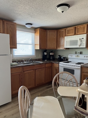 Enjoy cooking in this well-equipped kitchen with a stove, sink, coffee maker, and microwave.