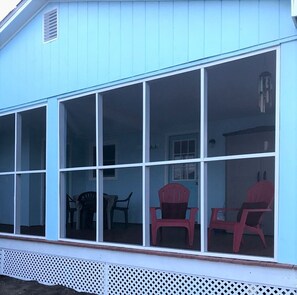 A blue building with a large glass windowed porch.
