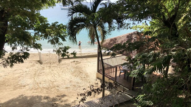 Une plage dotée d’une terrasse en bois et d’une zone délimitée par une clôture, avec vue sur la mer.