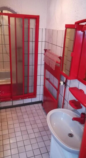 Ein Badezimmer mit Dusche, Waschbecken und Spiegel.