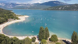 A coastal area with a beach, boats, and mountains in the background. - Village house with lake view (Sainte-Croix-Du-Verdon)