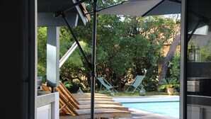 A poolside area with wooden lounge chairs and a pool. - NEW HOUSE, 700M FROM THE BEACH WITH A HEATED SWIMMING POOL AND A SPA (Labenne)