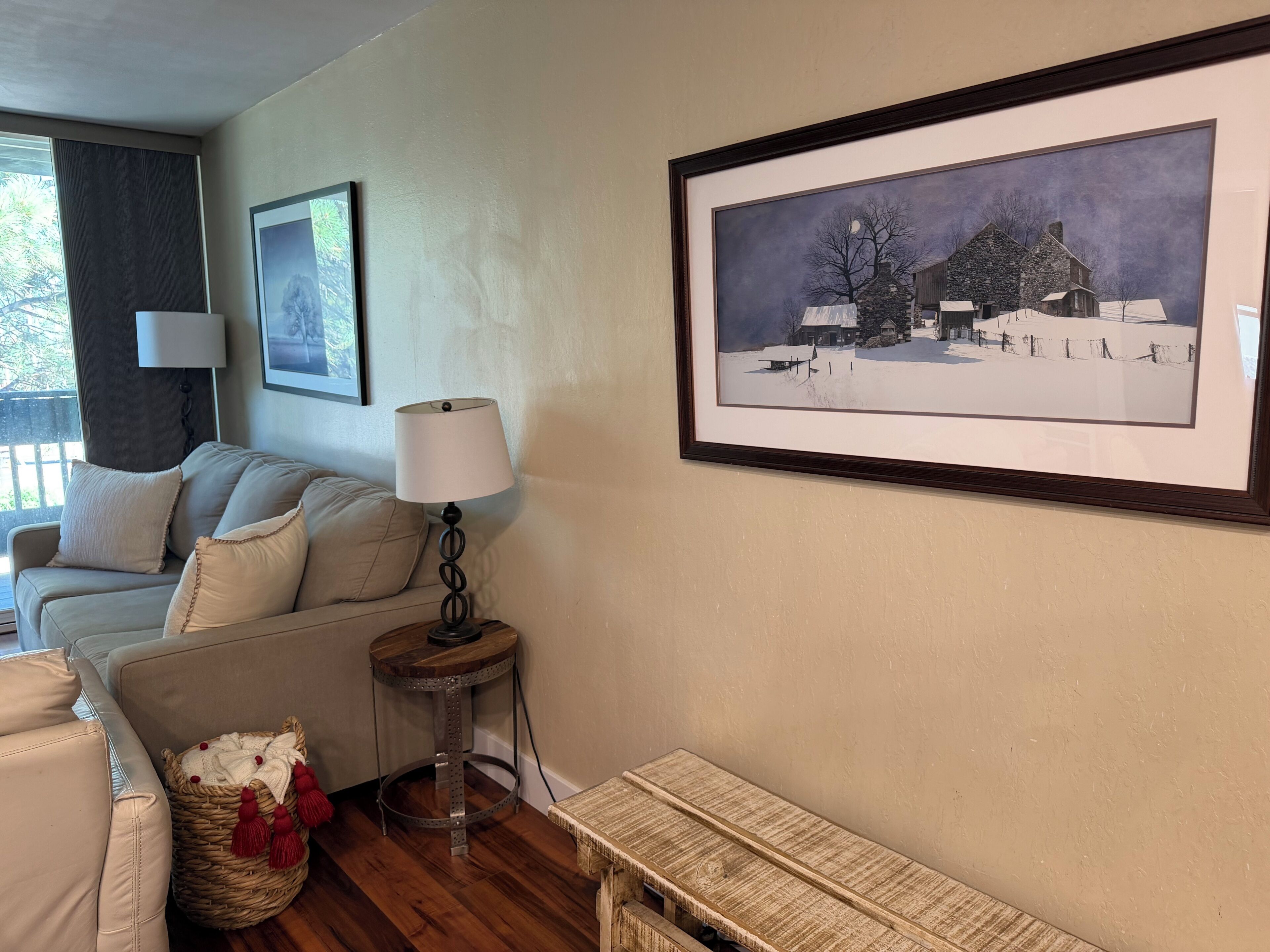 A cozy living room with a sofa, a lamp, a framed picture, and a small table.