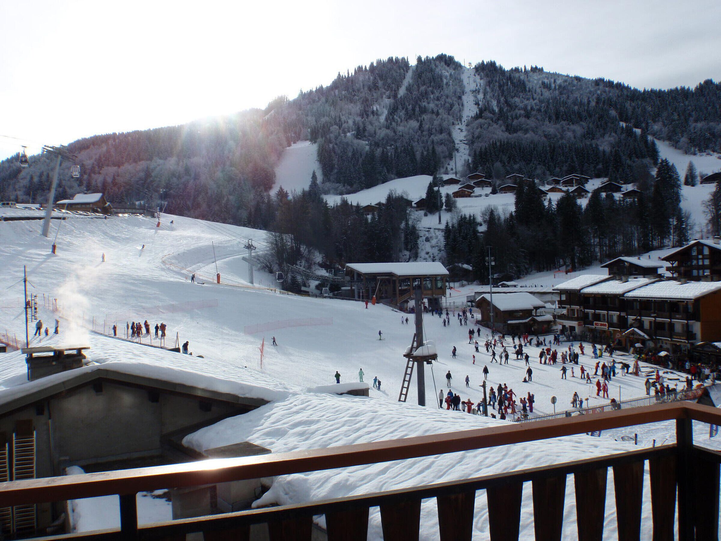 Une station de ski dotée d'un télésiège, de pistes enneigées et de bâtiments d'hébergement.