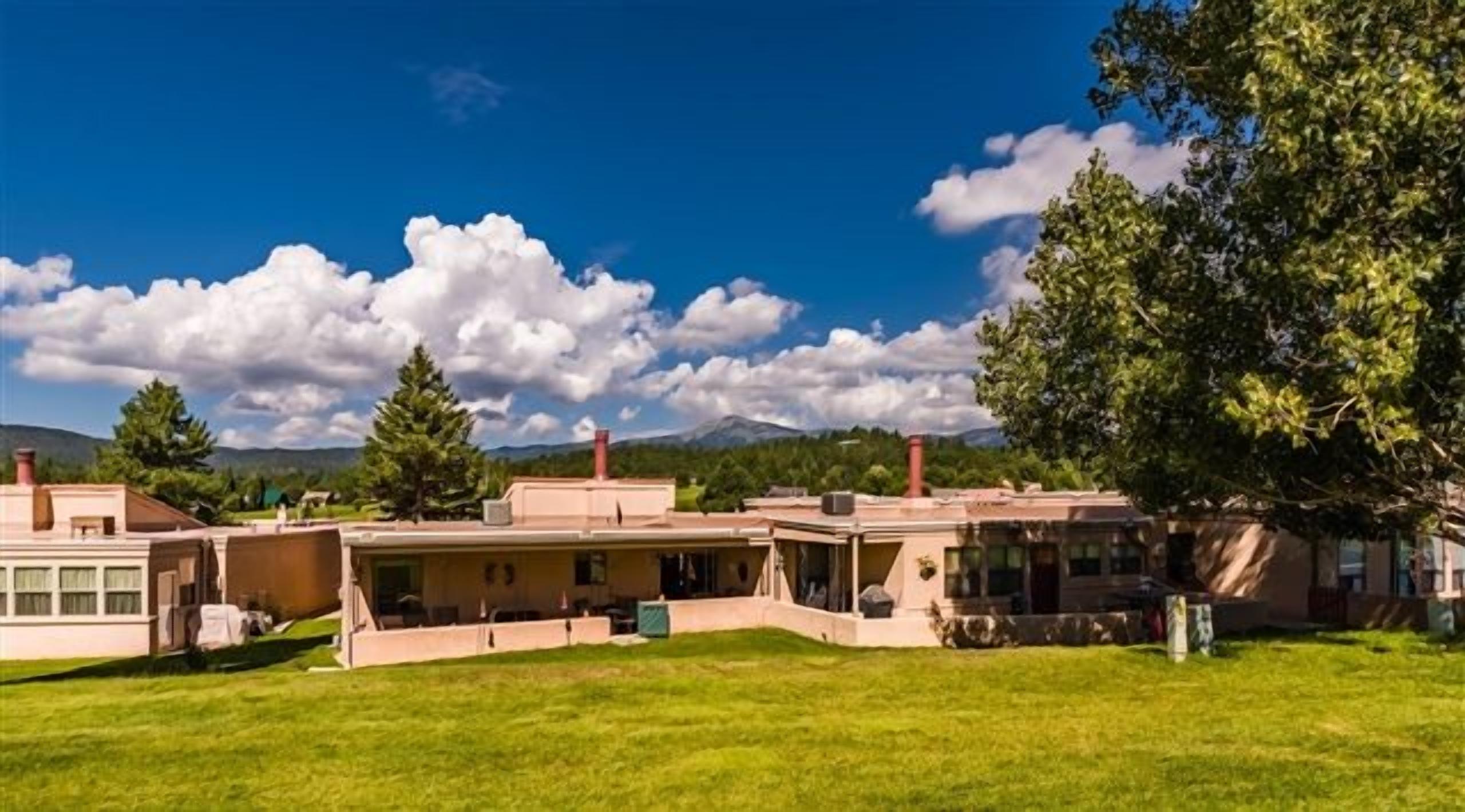 A large, single-story building with a spacious lawn in front.