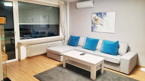 A modern living room with a sofa, a coffee table, and a radiator.