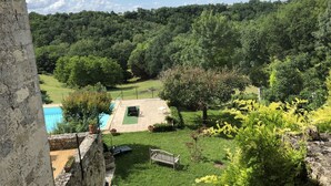 A lush garden with a pool, a bench, and a view of a forested hill. - In a listed village, half-timbered house overlooking a wooded valley (Montjoi)