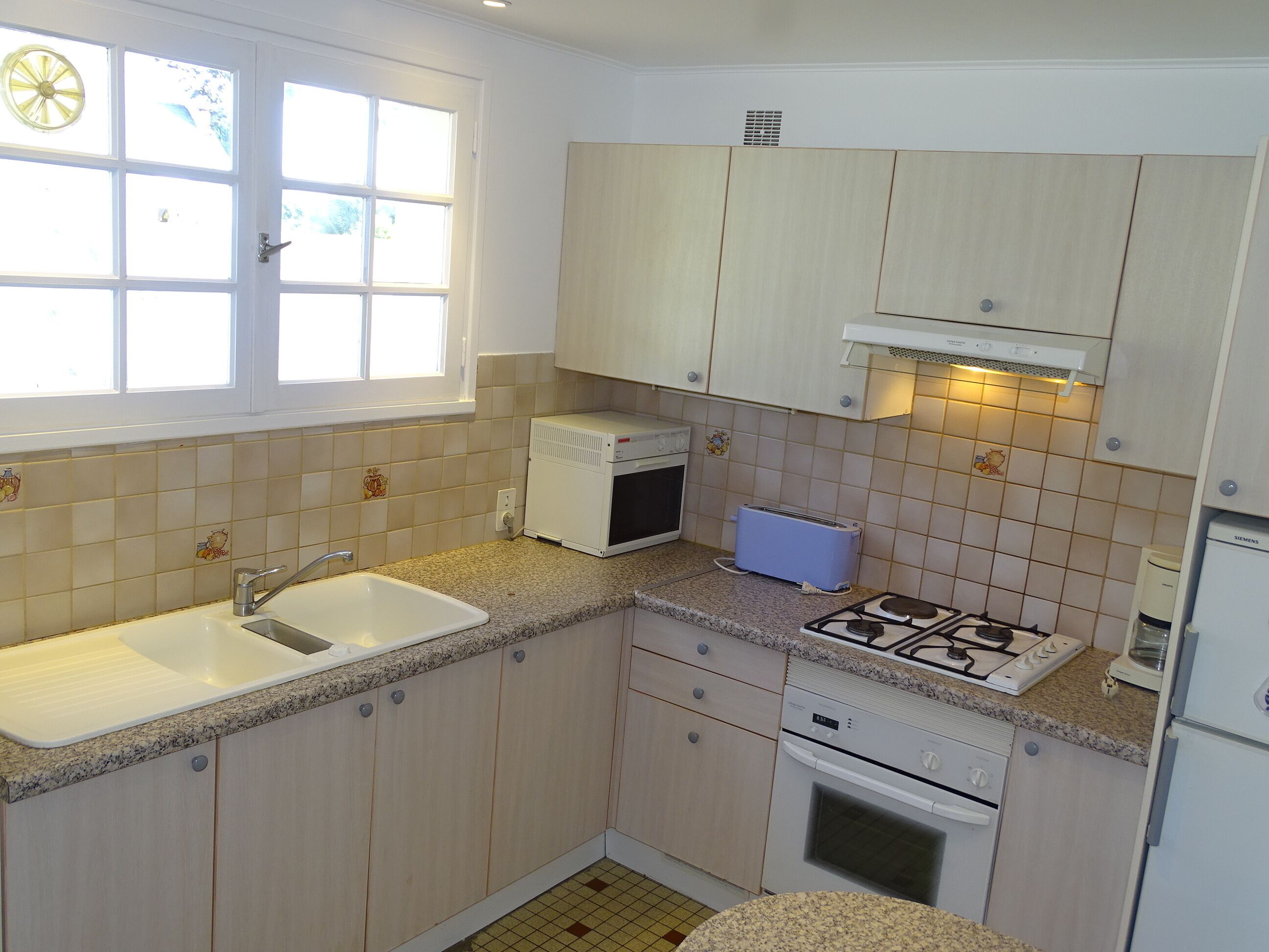 A compact kitchen with a sink, stove, and microwave.