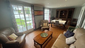 Un salon avec un canapé en cuir, une table basse en bois et un coin repas comprenant une table et des chaises.