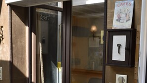 A hotel entrance with a sign reading "LA COLONIALE" and a poster advertising "CAFE DU COMPTOR COLONIALE". - The colonial furnished short-term (Saint-Malo)