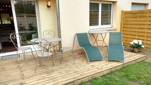 A wooden deck with outdoor furniture, including a table and chairs, and a potted plant. - Large and Charming Apartment in Obernai (Obernai)