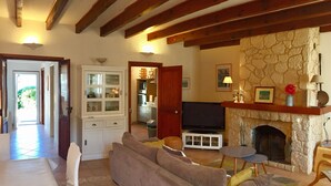 A living room with a stone fireplace, a television, and a sofa. - Waterfront self-catered house  (Coti-Chiavari)