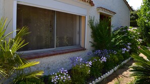 A house with a large window, a white picket fence, and various plants and flowers. - Waterfront self-catered house  (Coti-Chiavari)