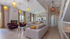 A spacious living area with a sofa, armchairs, and a coffee table. There are pendant lights and a fireplace. - Gorgeous home in Veprinac with sauna (Veprinac)
