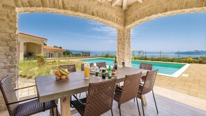 A covered outdoor dining area with a pool and a view of the sea. - Gorgeous home in Veprinac with sauna (Veprinac)