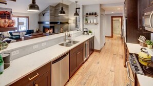 A modern kitchen with a central island, built-in appliances, and pendant lighting.