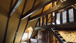 A bedroom with a wooden ceiling, a bed, a dresser, and a suitcase. - 4* TYPICAL HOUSE IN BARRIADE 4 pers (Mandailles)