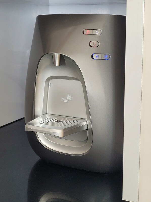 A modern water dispenser with a sleek design, a digital display, and a water bottle holder. - Breathtaking Views - Steps to the Beach and the Center of Town (Netanya)