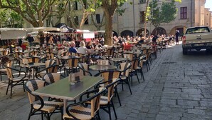 Outdoor seating with tables and chairs, a cobblestone street, and a parked vehicle. - Duplex Apartment 65m2 in quiet residence in Uzès, free Parking, garage in Option (Uzès)