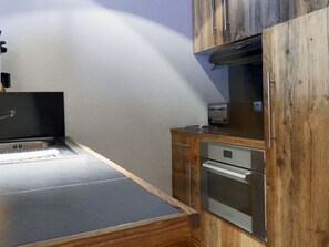A compact kitchen with a built-in oven, a toaster, and a sink. - Charming Duplex Chalet Style, 5 Pers, Méribel, 50m² (Méribel)