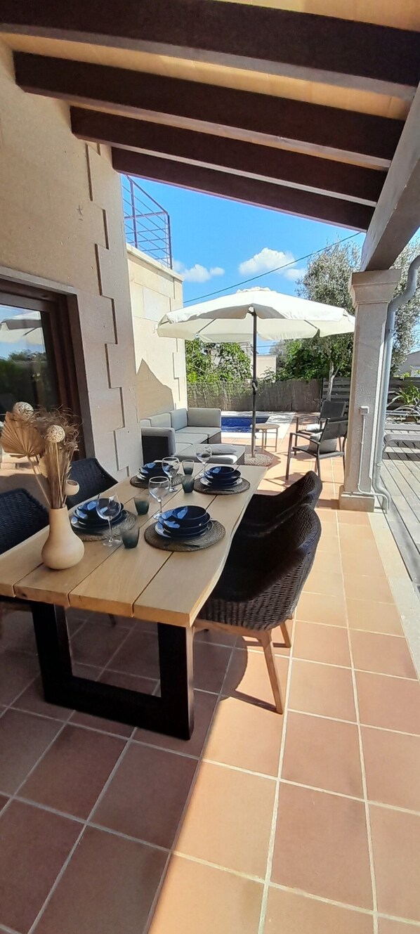 An outdoor patio with a dining table set for four, surrounded by chairs. - Superb house with pool - close to Cala Santanyi and Cala Llombards (Cala Santanyí)
