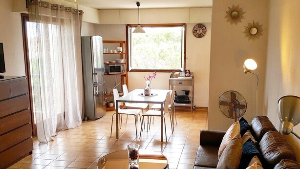 Una sala de estar con sofá, una mesa de centro y un comedor con mesa y sillas.