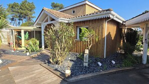 Een houten huis met een bord waarop verschillende steden en hun afstanden staan vermeld.
