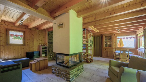 Un intérieur en bois avec une cheminée, des sièges et un escalier.
