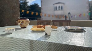 Tavolo apparecchiato all'aperto con vista su un edificio sullo sfondo.