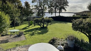 Un jardin bien entretenu, avec une pelouse, une petite table et un banc.