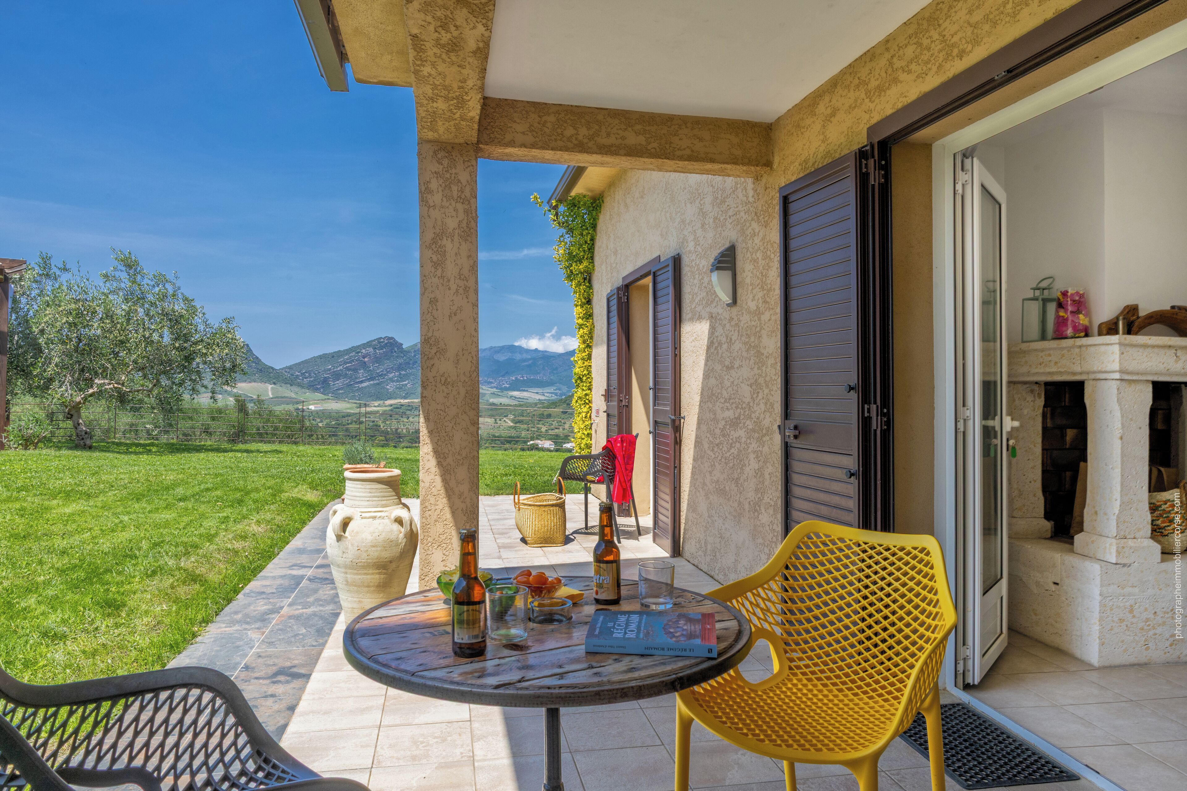 Eine Terrasse mit Tisch, Stühlen und Blick auf die Landschaft.