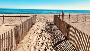 A sandy beach with wooden fences and a clear view of the ocean.