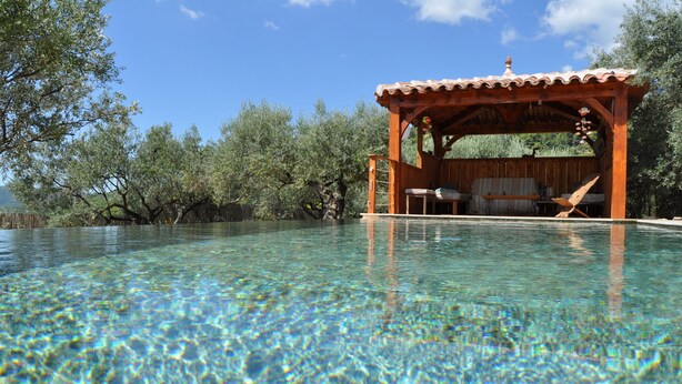 A clear pool with a wooden deck and lounge chairs. - beautiful house in olive grove, infinty pool and hot tub, panoramic view 8 pax (Callas)