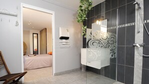 A modern bathroom with a glass shower enclosure, a white vanity, and a bed visible through an open door. - beautiful house in olive grove, infinty pool and hot tub, panoramic view 8 pax (Callas)