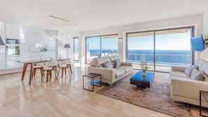A spacious living area with a large window overlooking the sea, a modern kitchen, and a seating area with a coffee table. - SUPER CANNES / GOLFE JUAN LUXURY APARTMENT SEA IMPRENABLE SEA. PRIVATE FLOOR (Vallauris)