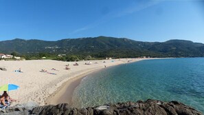 A beach with clear water, sandy shore, and mountains in the background. - Garden level, with direct access to plage.Au quiet, equipped, air-conditioned. (Calcatoggio)