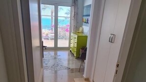 A hallway with a tiled floor leading to a balcony with a view of the beach. - Small house on the edge of the water totally renovated (estepona-Marbella-Andalousie)