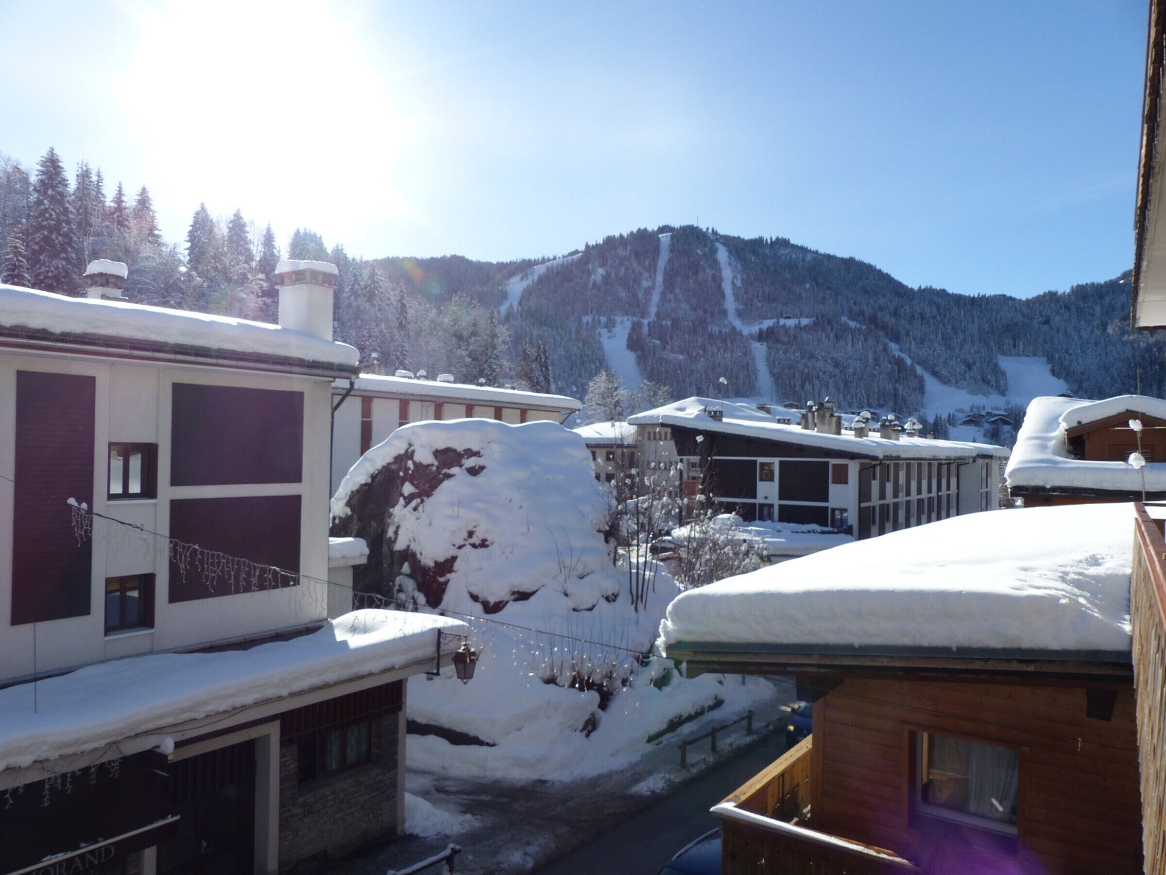 Une montagne enneigée, avec des bâtiments visibles au premier plan.