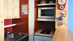 A compact kitchen with a sink, a microwave, and a small refrigerator.