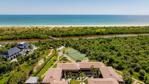 A resort with a tennis court, a river, and a beach.