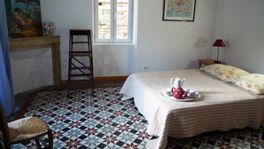Une chambre à coucher avec un lit, une chaise, une échelle, une fenêtre et un tableau accroché au mur.