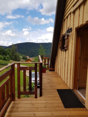 A wooden deck with a view of a forested mountain range. - Chalet les Epilobes with its unusual pointed hat and breathtaking view! (Xonrupt-Longemer)