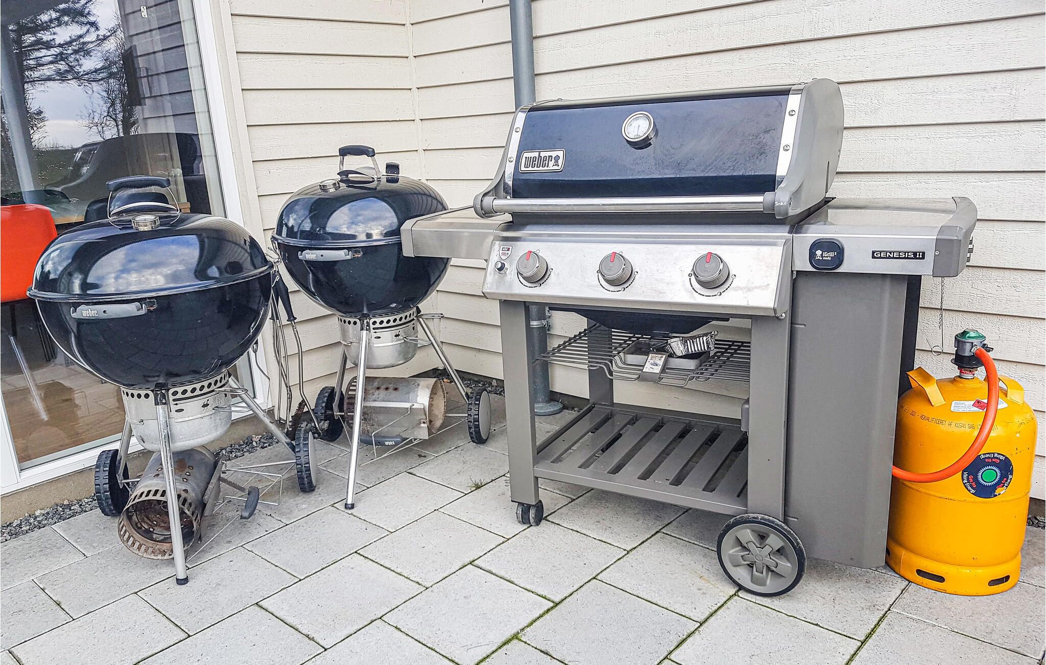 Ein tragbarer Gasgrill mit Seitentisch und Gasflasche.