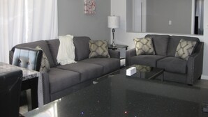 A modern living room with a grey sofa, patterned cushions, a coffee table, and a lamp. - Elegant Las Vegas rental (Las Vegas)