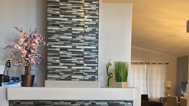 A modern living room with a fireplace, a decorative wall panel, and a potted plant. - Elegant Las Vegas rental (Las Vegas)