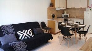 A compact living space with a sofa, dining table, chairs, a kitchenette, and a microwave. - House 4 km from Cargese. (Cargèse)