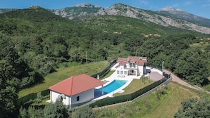 A modern villa with a swimming pool, surrounded by lush greenery and mountains. - Luxurious home in Hrvace (Hrvace)