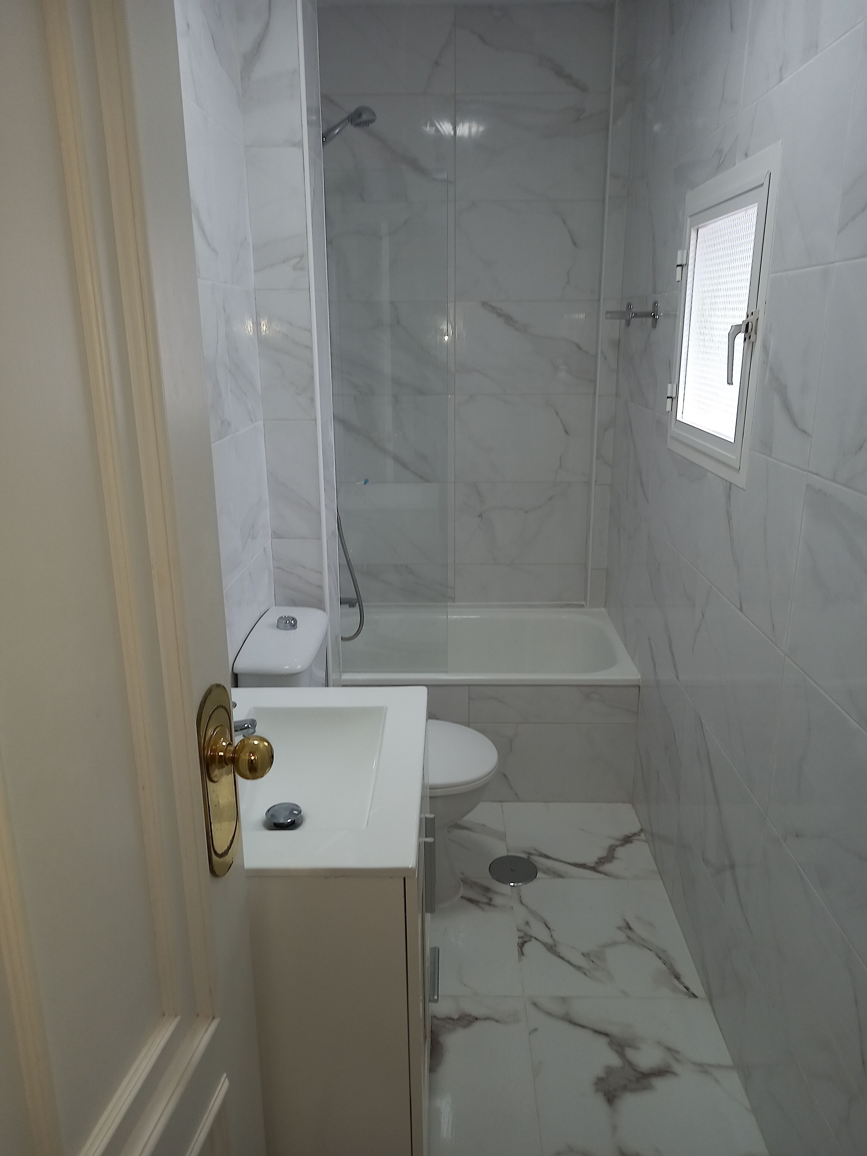 Un baño con inodoro, lavamanos y ducha.